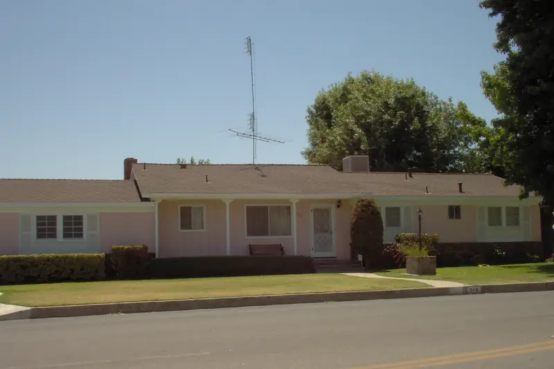 A low 1950s California ranch house with a box-shaped evaporative cooler sitting on its roof